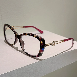 Detail of tortoiseshell cat-eye frames with elegant golden hollowed-out metal temples