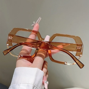 Detailed close-up of amber tortoiseshell eyewear frame with white crystal embellishments