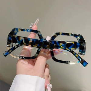 Macro detail of blue tortoiseshell oversized glasses frame with silver rhinestone accents