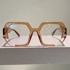 Detail of light amber translucent irregular geometric eyeglass frames on a minimalist stand