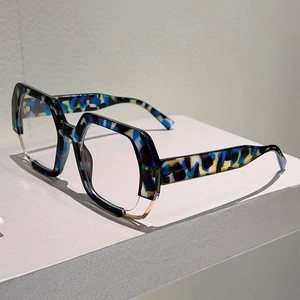 Macro detail of geometric hexagonal eyeglasses with colorful tortoiseshell texture and gold trim