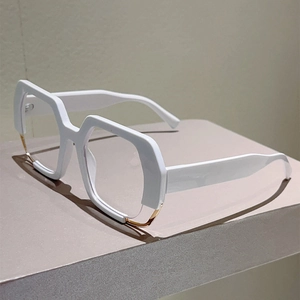 Detail of white acetate wide temples and gold metal accents on oversized eyewear frame