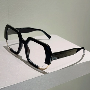 Detail of geometric black eyewear frame with distinctive gold metal trim on bottom