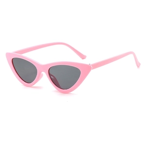 Close-up of pink cat-eye sunglasses with thick plastic frames and dark lenses