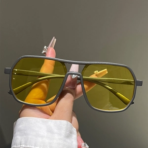Close-up of retro aviator sunglasses with yellow lenses and double bridge metal frame