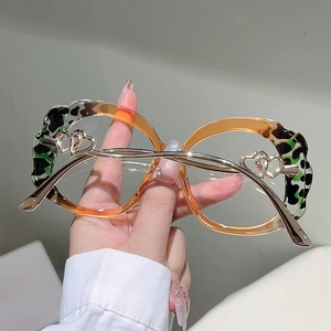 Close-up of leopard print eyewear featuring metal heart embossing on the hinge