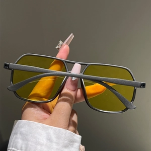 Detailed shot of aviator sunglasses with matte black frames and yellow tinted lenses