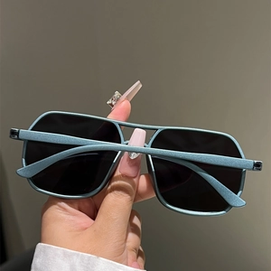 Detail view of matte blue rectangle sunglasses with a double-bridge frame and dark lenses