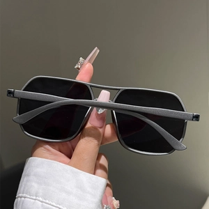 Close-up of matte grey double-bridge aviator sunglasses with dark black square lenses