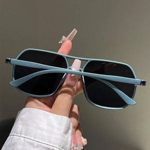 Detailed close-up of teal blue double bridge square frame sunglasses with black lenses