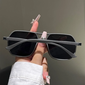 Detail of grey geometric square sunglasses with matte finish and dark tinted lenses