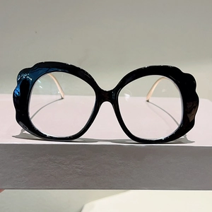 Detailed view of black wavy petal-edged frames with elegant slim gold metal temples