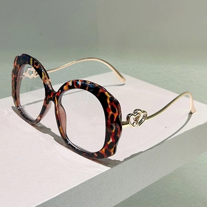 Detail of leopard print round frames with gold metal temples and hollow heart accents