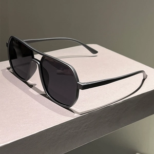 Detail view of double-bridge pilot sunglasses with matte black frame and grey lenses