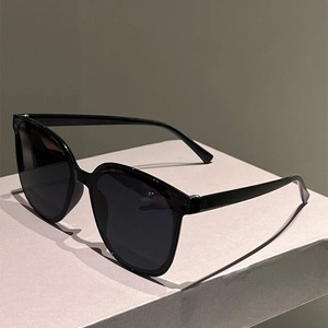 Detail of classic black square sunglasses with glossy frames on a display stand