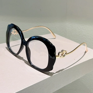Detailed side view of wavy black eyeglass frames with gold hollow heart temple accents