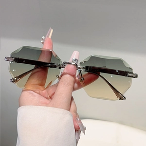 Detail of rimless hexagon sunglasses with gradient lenses and heart crystal on nose bridge
