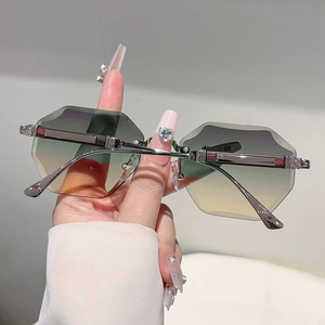 Detailed close-up of rimless hexagonal sunglasses with gradient lenses and metal temples