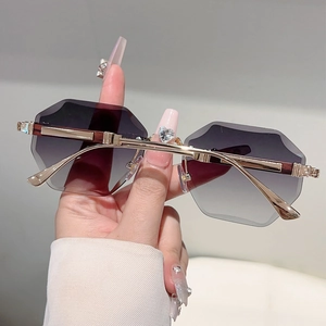 Macro view of rimless hexagon sunglasses with gradient purple lenses and gold metal frame