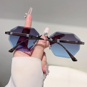 Detail of rimless hexagonal sunglasses with blue-purple gradient lenses and metal frame