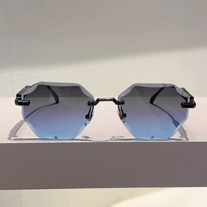 Detail of rimless hexagonal sunglasses with blue gradient lenses and slim metal bridge