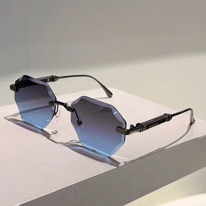 Close-up of frameless hexagonal sunglasses with blue gradient lenses and metal temples