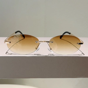 Frameless small oval sunglasses with brown gradient lenses and slim gold metal temples