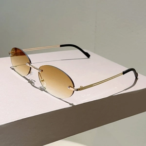 Detail of rimless oval sunglasses featuring brown gradient lenses and slim gold metal temples