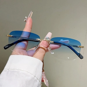 Dettaglio ravvicinato di occhiali da sole senza montatura con ponte dorato e lenti blu