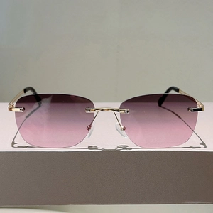 Dettaglio di occhiali da sole senza montatura con lenti sfumate rosa e montatura in oro