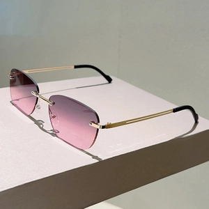 Occhiali da sole ovali senza montatura dorata con lenti rosa sfumate alla moda