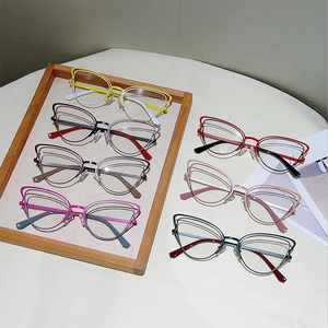 Detail of multi-color cat-eye metal frames in seven trendy shades on a wooden tray