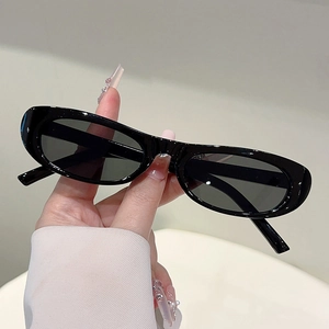 Close-up of retro oval sunglasses featuring glossy black frames and wide chunky temples