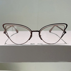 Detail view of burgundy cat-eye glasses featuring unique double-layer metal frame design