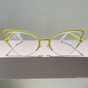 Detail of yellow cat-eye metal glasses frame featuring unique hollow layered design