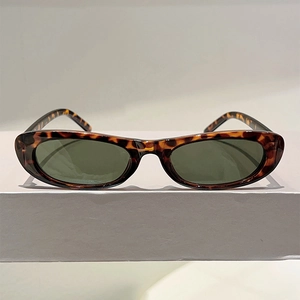 Detailed view of vintage oval sunglasses featuring tortoiseshell frames and dark green lenses