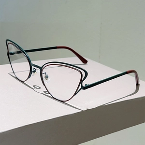 Detail of cat-eye glasses frame with dual-layer dark green and burgundy metal finish
