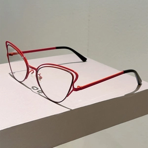 Detail of red cat-eye glasses with hollow double-line metal frame and black temple tips