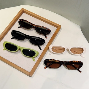 Vintage oval sunglasses collection in assorted colors on a wooden display stand