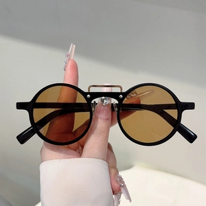 Détail de lunettes de soleil rondes rétro avec monture noire et double pont doré