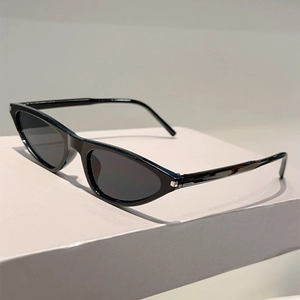 Close-up of black Y2K cat-eye sunglasses with silver hinge detail on a minimal stand