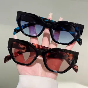 Detail of stylish cat-eye sunglasses with blue and red gradient lenses and tortoise temples