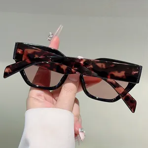 Detail view of stylish tortoiseshell rectangle sunglasses with wide amber textured frames