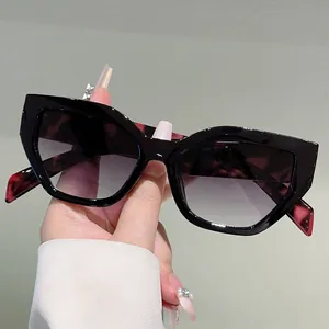 Detail of stylish cat-eye sunglasses with thick black frame and gradient grey lenses