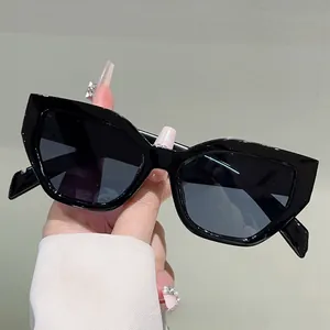 Close-up of black oversized cat-eye sunglasses with thick geometric frame and dark lenses