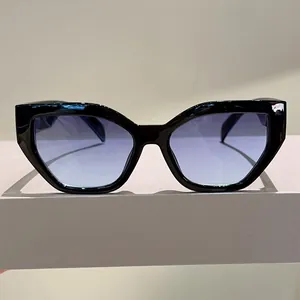 Macro detail of black cat-eye sunglasses with gradient blue lenses on gray background
