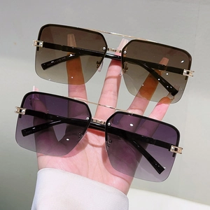 Detail of square gradient sunglasses with gold metal bridge and rimless frame design