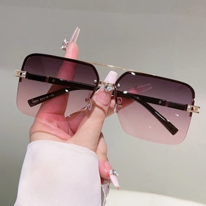 Detailed close-up of gradient lenses and heart-shaped diamond accents on gold sunglasses