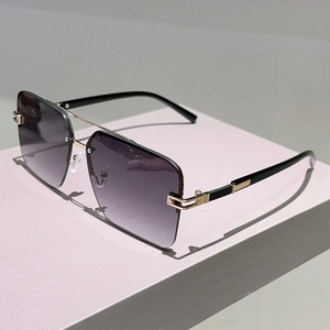 Detailed view of square rimless sunglasses with gold C-shape metal hardware and gradient lenses