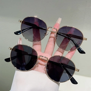 Detail of round gold metal sunglasses with purple gradient and classic black lenses